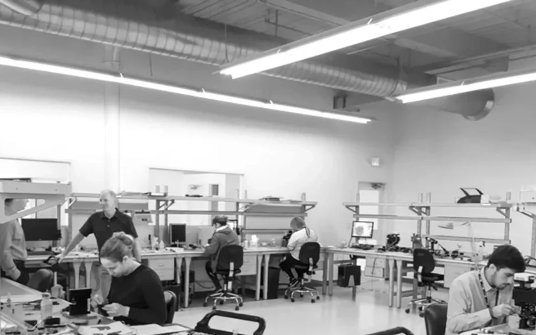 Industrial collaborative robot positioned beside a configured workstation in a production cell